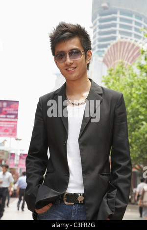 Smiling Chinese man standing outdoors Stock Photo