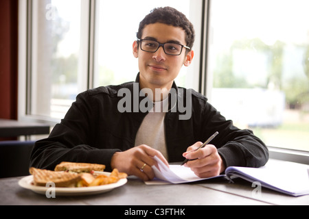 Hispanic student studying in diner and having lunch Stock Photo