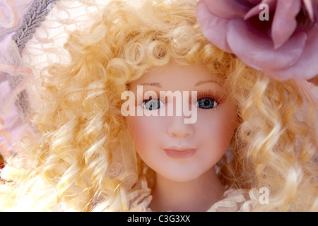 antique old blond porcelain doll face portrait curly hair Stock Photo