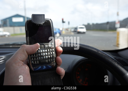 man using mobile phone when driving in the uk Stock Photo