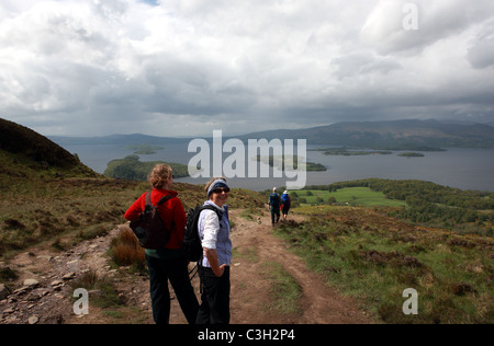 Walkers on Conic Hill admiring the view over Loch Lomond in Scotland Stock Photo