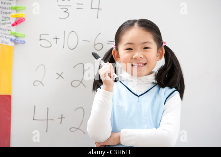 A young student standing proudly in front of her work Stock Photo