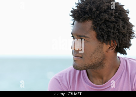 portrait of young african american guy looking away near the sea. Horizontal shape; head and shoulders; copy space Stock Photo