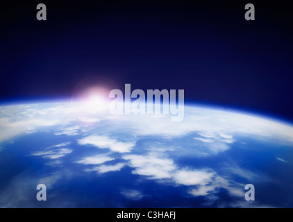 Space with rising sun above planet earth Stock Photo