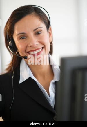Portrait of a smiling female customer representative with phone headset ...