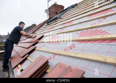 Man Nailing New House Roof Tiles Standing on Scaffolding, Re Roofing Residential Home by Ontop Roofing, Sheffield, England Stock Photo