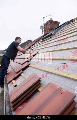 Man Nailing New House Roof Tiles Standing on Scaffolding, Re Roofing Residential Home by Ontop Roofing, Sheffield, England Stock Photo