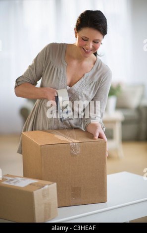 Woman taping cardboard boxes Stock Photo