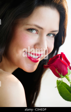 Woman smelling a red rose Stock Photo - Alamy