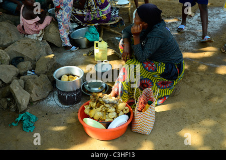 Woman preparing food next to road in Beni, Eastern Democratic Republic of Congo in January 2011. Stock Photo