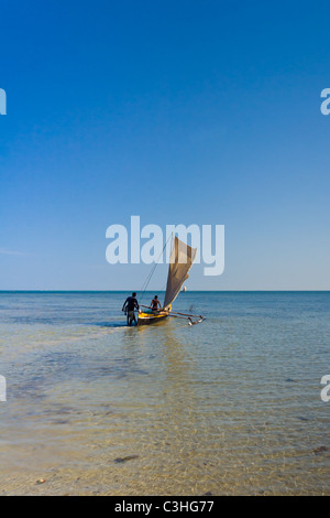 Malagasy outrigger pirogue with makeshift sails Stock Photo