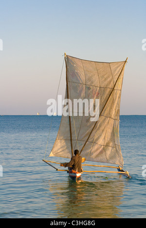 Malagasy outrigger pirogue with makeshift sails Stock Photo