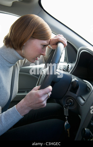 Woman driving car looking upset Stock Photo