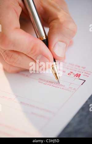 Hand filling tax form Stock Photo