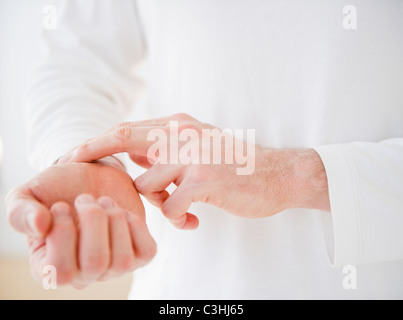 Hands taking pulse Stock Photo