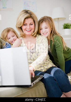 Mother and daughters (8-11) using laptop Stock Photo
