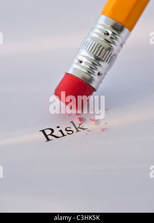 Studio shot of pencil erasing the word risk from piece of paper Stock Photo