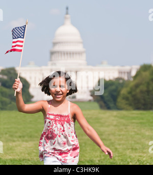 USA, Washington DC, girl (10-11) with US flag running in front of Capitol Building Stock Photo