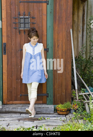 Young woman standing at front door Stock Photo