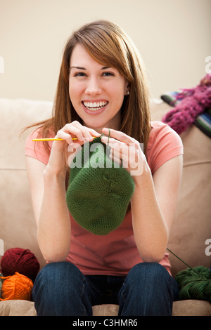 Young woman knitting woolly hat Stock Photo