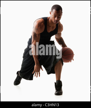 Studio shot of man playing basketball