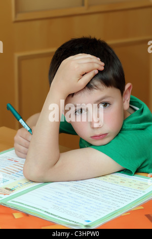 boy doing homework from school in workbook Stock Photo