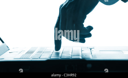 Close-up of hand touching computer keys during work Stock Photo