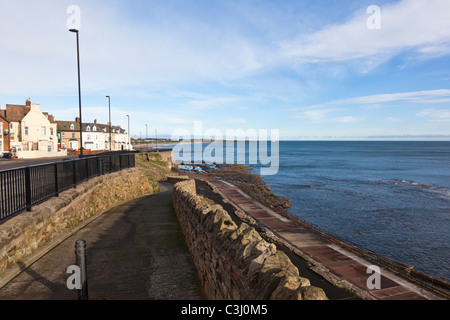 Promenade at Cullercoats, North Tyneside, with St Mary's Island and lighthouse in the distance across Whitley Bay Stock Photo