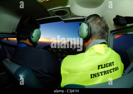 Flying instructor with student pilot during a night flight in a Cessna 172 over  Luxembourg country Stock Photo