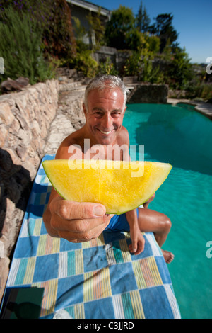 Senior man relaxing at swimming pool Stock Photo