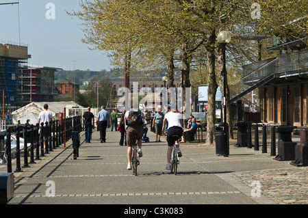 dh Quayside promenade BRISTOL DOCKS BRISTOL Young couple riding bicycles along cycling uk harbourside friends city bike ride waterfront cycles Stock Photo
