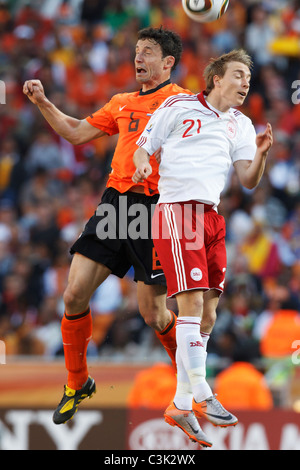 Mark van Bommel of the Netherlands (l) and Christian Eriksen of Denmark (r) jump for a header during a 2010 World Cup match. Stock Photo