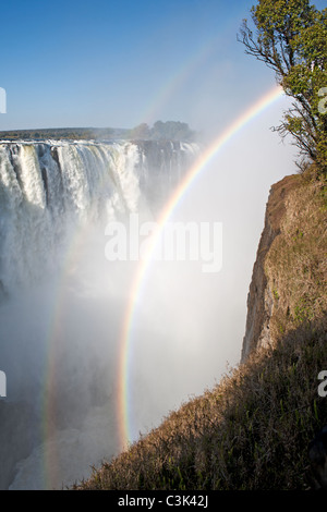 In the afternoon, rainbows form in Victoria Falls' mist on the Zimbabwe side of the falls. Stock Photo