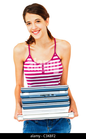 Smiling woman holding a stack of laptops isolated over white Stock Photo