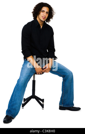 Man sitting on a stool and posing isolated over white Stock Photo
