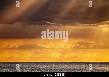 A colorful golden sunset with clouds off of Waikiki beach, Honolulu, Hawaii. Stock Photo