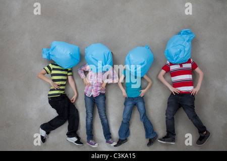 People covering their faces with plastic bags and showing ecology symbol Stock Photo