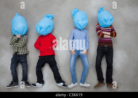 People covering their faces with plastic bags and showing ecology symbol Stock Photo