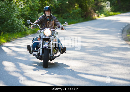 Senior man riding vintage motorbike Stock Photo