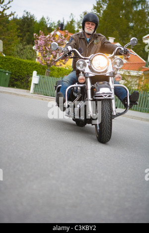 Senior man riding vintage motorbike Stock Photo