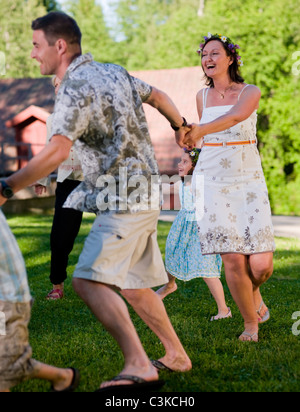 Man, woman and children dancing in circles Stock Photo