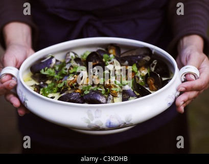 Woman holding pot of mussels, close-up Stock Photo