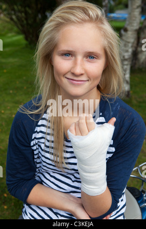 Teenage girl with bandage on hand, smiling, portrait Stock Photo