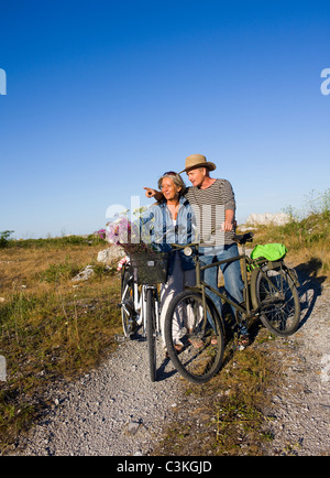 Mature couple riding bicycle on beach Stock Photo