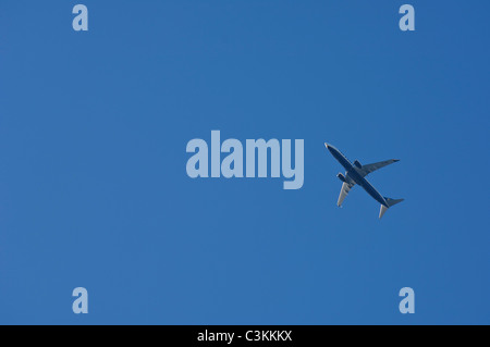 Low angle view of passenger jet flying against blue sky Stock Photo