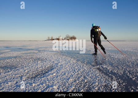 Man ice skating on snow covered landscape Stock Photo