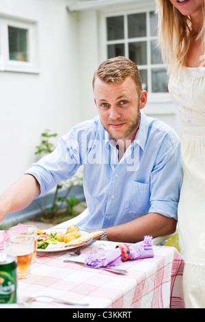 Young man and young woman dining outdoors Stock Photo