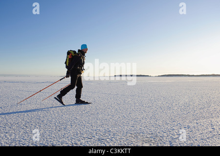 Man ice skating on snow covered landscape Stock Photo