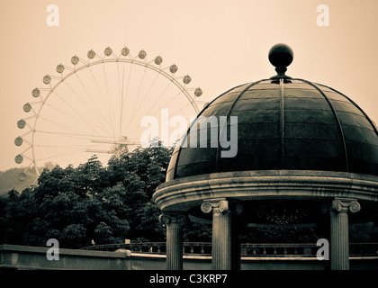 Antiqued effect on a columned pagoda and ferris wheel, off in the distance. Stock Photo