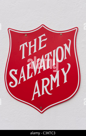 Close-up of famous iconic Salvation Army logo sign, fixed to exterior wall of church (white name & letters on red shield) - Tadcaster, England, UK. Stock Photo